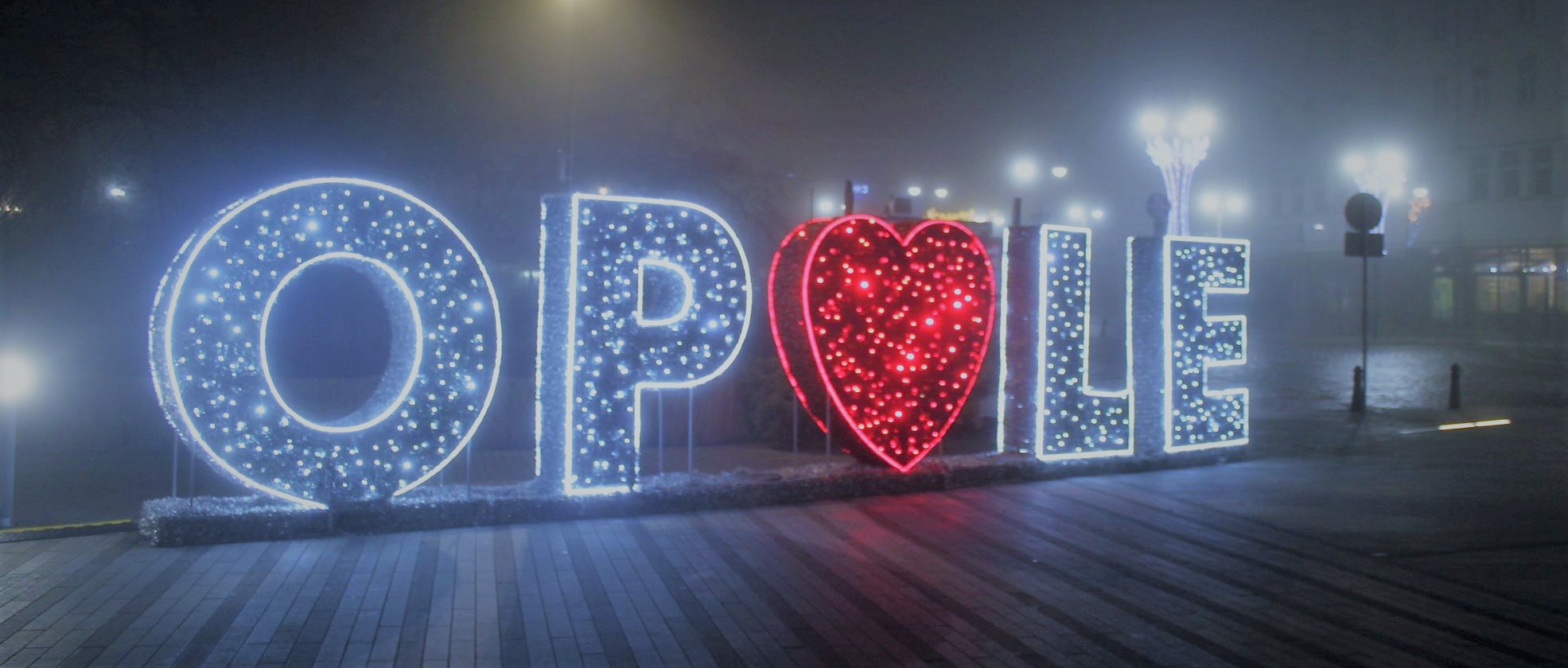 Zdjęcie zrobione nocą przedstawiające podświetlony napis OPOLE. 
